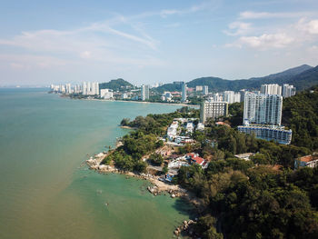 High angle view of city by sea against sky