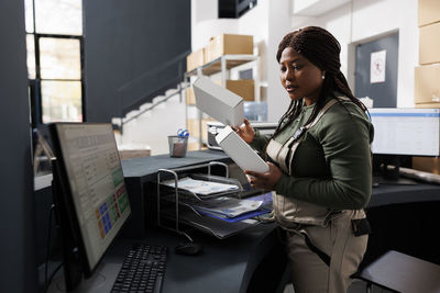 Portrait of young man using mobile phone in office