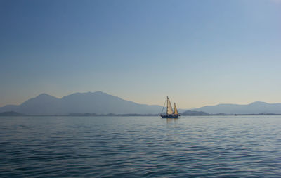 Sailboat sailing in sea against clear sky