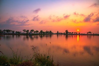 Scenic view of lake against romantic sky at sunset