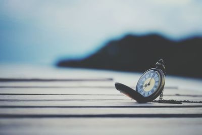 Close-up of clock on table against blurred background