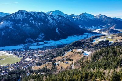 Aerial view of townscape by mountains against sky