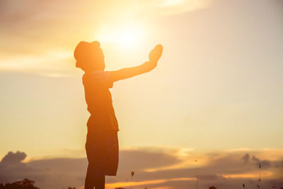 Silhouette man standing against sky during sunset