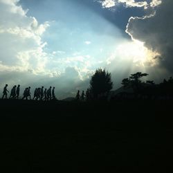 Silhouette of trees against cloudy sky