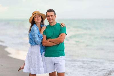 Portrait of smiling friends standing at beach