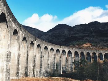 Glenfinnan viaduct by mountains against sky