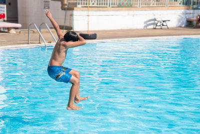 Full length of man jumping in swimming pool