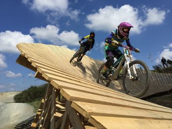 People riding bike in bikepark against sky