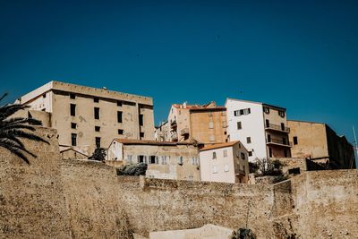 Low angle view of buildings against clear blue sky