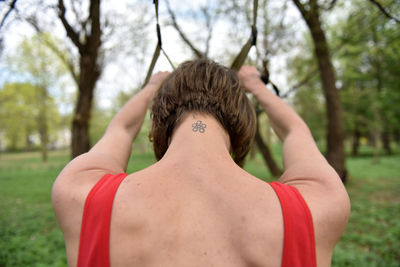 Rear view mid adult woman exercising at park