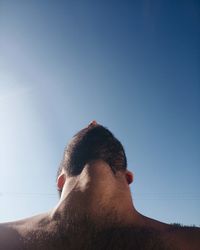 Rear view of shirtless man against sky