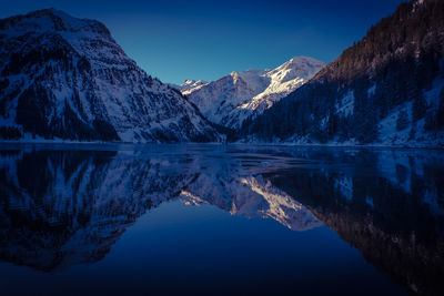 Scenic view of lake and mountains against blue sky