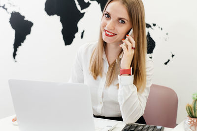 Happy businesswoman travel agent using laptop for communication and work on-line travel agency 