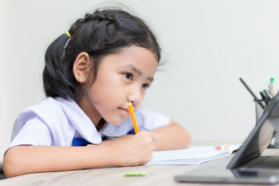 Girl using digital tablet at table