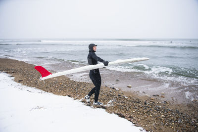 Full length of man standing on beach against sky