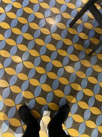 Low section of person standing on tiled floor