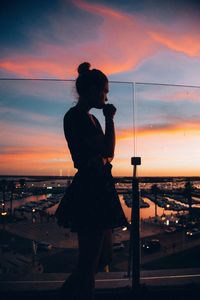 Silhouette woman standing at beach during sunset