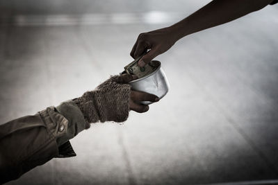 Cropped image of beggar and person at street