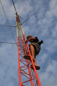 Low angle view of man working at construction site against sky