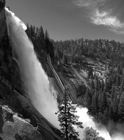 Scenic view of waterfall against sky