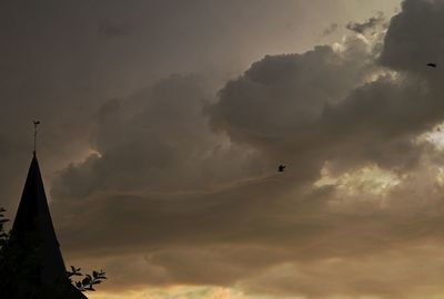 Low angle view of silhouette birds flying against sky