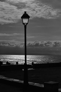 Street light by sea against sky