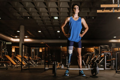 Man with artificial leg standing in gym