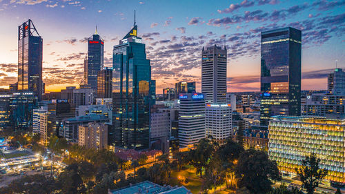 Illuminated buildings in city at dusk