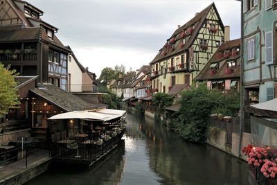 Canal amidst buildings in town against sky