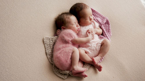 Two girls twins newborn sleep in bed