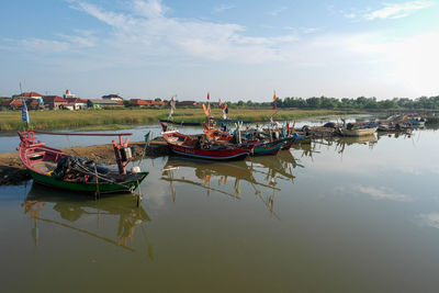 Boats moored in lake against sky