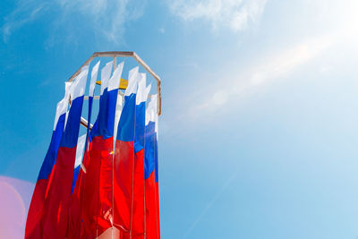 Low angle view of colorful balloons against blue sky