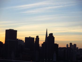 Skyscrapers in city at sunset