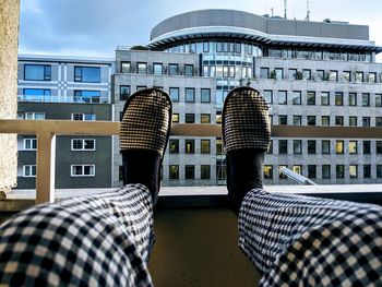 Rear view of man and buildings against sky in city