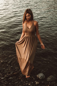 Young woman standing by lake