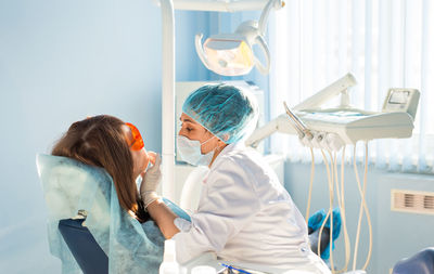 Nurse wearing mask examining patient at hospital