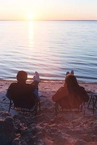 Rear view of people relaxing on beach