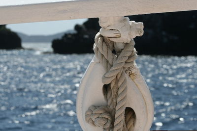 Close-up of rope sculpture against sea