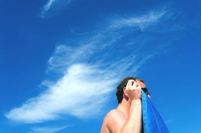 Low angle view of woman against blue sky