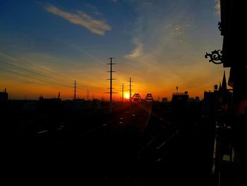 Silhouette city against sky during sunset