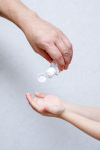 Close-up of hand holding hands over white background