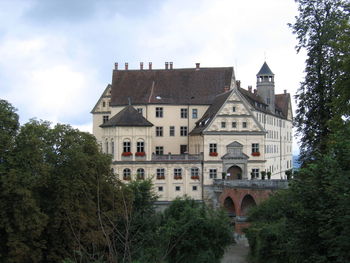 Old building by trees against sky