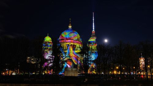 Low angle view of illuminated building against sky at night