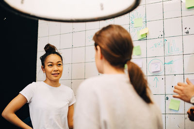 Smiling young businesswoman planning with hackers at creative office