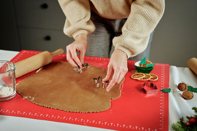 Process of woman making gingerbread cookies at home