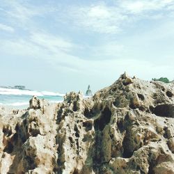 Rocks on beach against sky