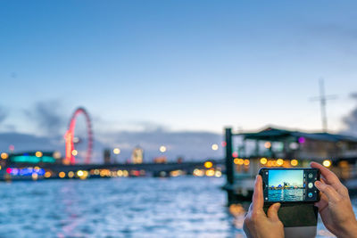 Bridge over river in city against sky