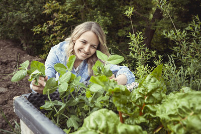 Portrait of a smiling young woman holding plants