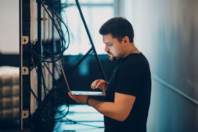 Side view of man using digital tablet in office