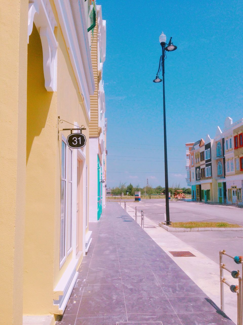 architecture, building exterior, built structure, city, residential building, blue, the way forward, residential structure, street light, modern, residential district, day, footpath, outdoors, sky, city life, skyscraper, development, architectural column, diminishing perspective, tall - high